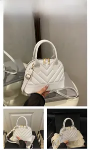 Macro shot of white V-quilted shell bag with premium gold double zippers and PU leather