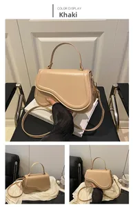 Detail view of the khaki saddle-shaped handbag with premium leather texture and hardware