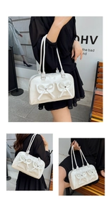 Detail of white PU shoulder bag featuring dual bow pockets and silver zipper accents