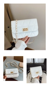 Detail of white quilted handbag featuring triangular stitching and gold metal twist lock