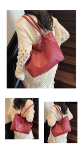 Detail of red oversized tote bag featuring a woven pattern texture and long shoulder straps