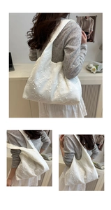 Close-up of white canvas hobo bag featuring delicate 3D lace floral embroidery details