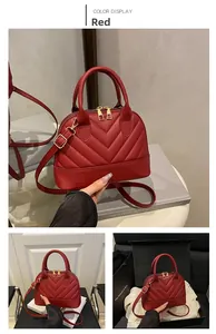 Detail of red shell bag featuring V-shaped quilting and golden metal zipper hardware