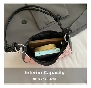 Internal view of pink and black crossbody bag showing storage capacity for phone and makeup