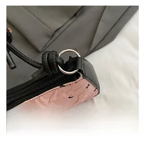 Close-up of polished silver metal rings and black zipper on pink bow print handbag