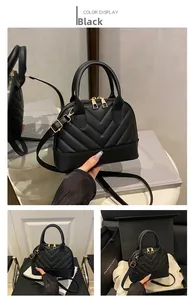 Detail of black quilted shell bag with V-shaped stitching and golden hardware zippers