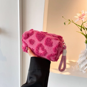 Plush pink makeup bag with heart pattern and purple handle for travel organization
