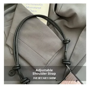 Detail view of the adjustable knotted strap on a pink bow baguette bag