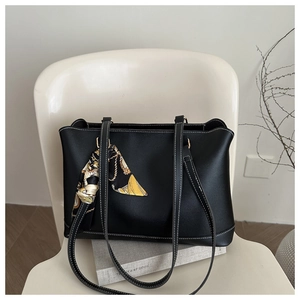 Detail of black tote bag with white contrast stitching and decorative floral silk scarf