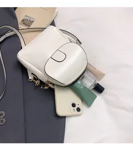 Detail of cream white crossbody bag capacity showing phone and cosmetic storage
