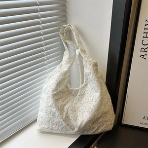 Minimalist white floral lace canvas tote bag with embroidered daisy details on a windowsill