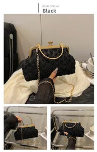 Detailansicht einer eleganten schwarzen Abendtasche mit 3D-Blumen und Goldkette
