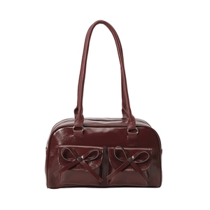 Deep red patent leather bow shoulder bag with two front pockets and a vintage bowling style