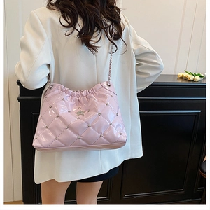 Detail of light pink quilted chain bucket bag with star sequins and crystal accents