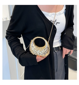 Model carrying a gold quilted acrylic handbag with a metallic finish and chain strap