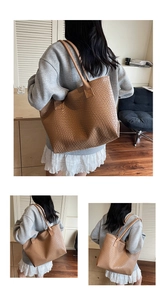 Detailed woven texture of a large brown tote bag with shoulder straps for women