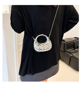 Close-up of silver quilted mini bag with round handle and metal chain strap details