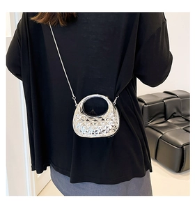 Rear view of a model wearing a metallic silver quilted crossbody bag with chain strap