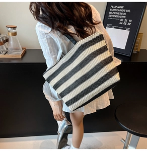 Model wearing a large black and white striped woven tote bag for daily commuting