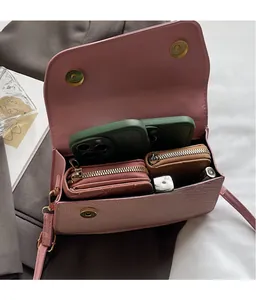 Intérieur de la sacoche rose montrant l'espace pour smartphones et portefeuille