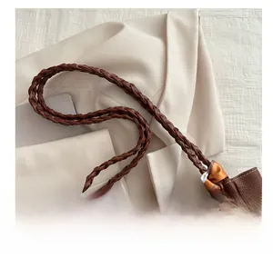 Close-up of litchi texture brown leather tote with woven straps and silk scarf