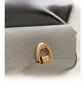 Detail of silver sequin texture and golden horseshoe metal lock on trendy handbag