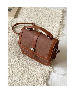 Detailed view of brown woven texture and smooth leather finish on small square crossbody bag