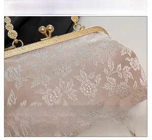 Détails du sac en satin champagne vintage avec broderie florale et fermoir en métal gravé