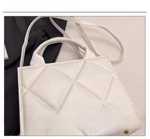 Vue détaillée du sac cabas en similicuir blanc avec coutures géométriques et texture