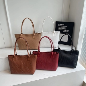 Retro woven texture large tote bags in five colors displayed on a white podium