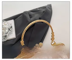 Détail du tissu jacquard floral doré et de la poignée en métal rétro du sac de soirée