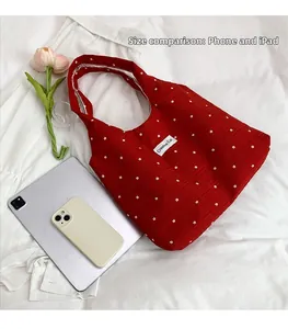 Comparaison détaillée de la taille du cabas en toile à fleurs avec tablette et mobile