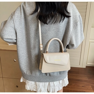 Détail du sac bandoulière en cuir blanc et tissé, vue arrière sur un mannequin