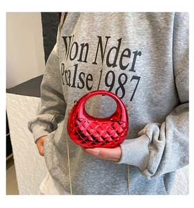 Detail der roten Acryl-Muscheltasche mit Rautenmuster und goldener Kettenriemen