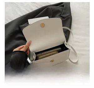 Detail view of the interior capacity showing a white quilted crossbody bag with a phone and wallet