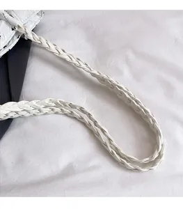 Detail of woven white leather handle and black bow print with silver chain link