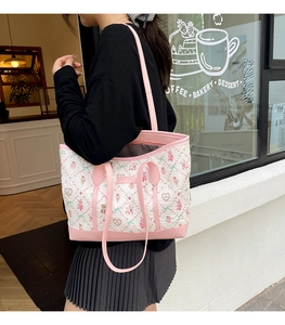 Outdoor shot of a pink cartoon heart embroidered tote bag with leather straps for women