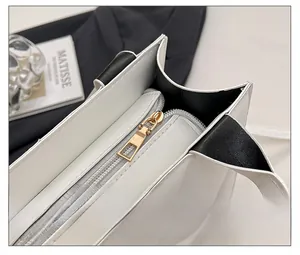 Gros plan sur la fermeture éclair en métal doré du sac fourre-tout matelassé noir et blanc