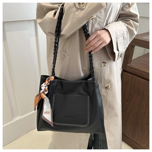 Close-up of black lychee grain tote bag featuring contrast stitching and a silk scarf