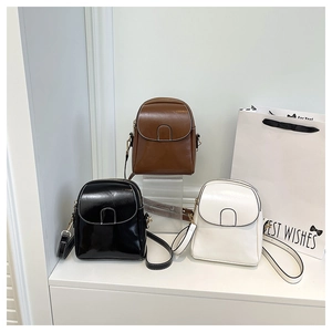 Three sleek PU leather shoulder bags in black, brown, and white displayed on a white stand