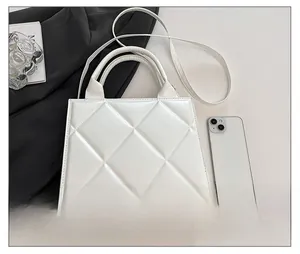 Détail du sac cabas blanc matelassé avec clous dorés et référence de taille téléphone