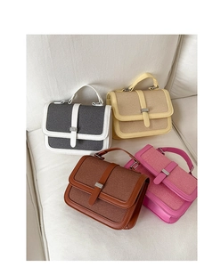 Macro shot of stylish square bags in grey, yellow, brown, and rose on a white sofa