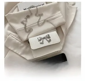 Detailed macro of white mini bag with snake pattern texture and silver bow buckle