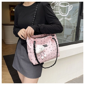 Pink quilted tote bag with bow prints, woven strap and soft white cloud charm detail