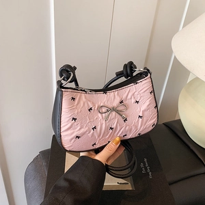 Pink pleated underarm bag with black bow print and metal bow detail for women
