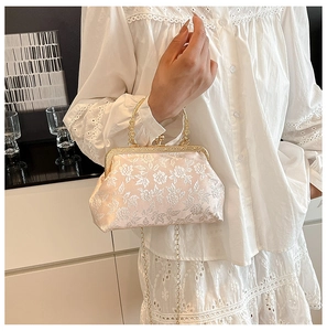 Détail du sac de soirée en jacquard fleuri rose clair avec anse dorée et chaîne