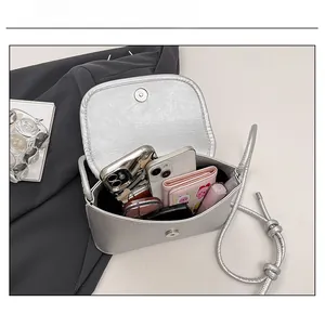Silver metallic crossbody bag showing interior capacity for phone and wallet