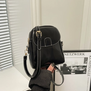 Fashionable black small crossbody phone bag with contrast white stitching and gold metal buckle