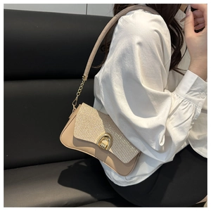 Close-up of beige shoulder bag with sparkling sequins and golden horseshoe metal buckle