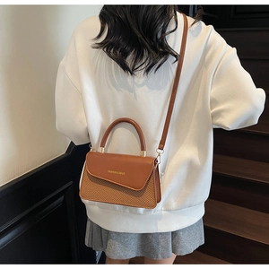 Vue arrière du modèle portant un sac bandoulière en cuir marron et paille avec poignée